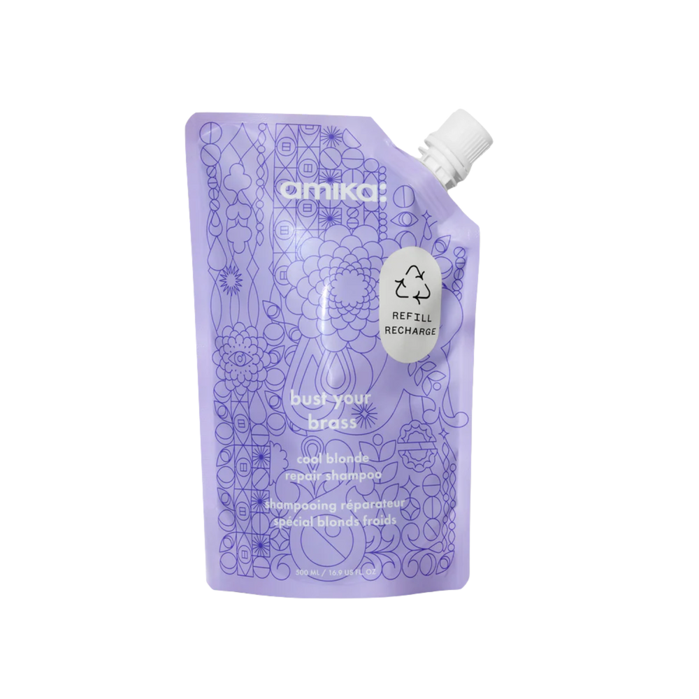 Flacon du shampoing Amika Bust Your Brass 275 ml posé sur fond blanc