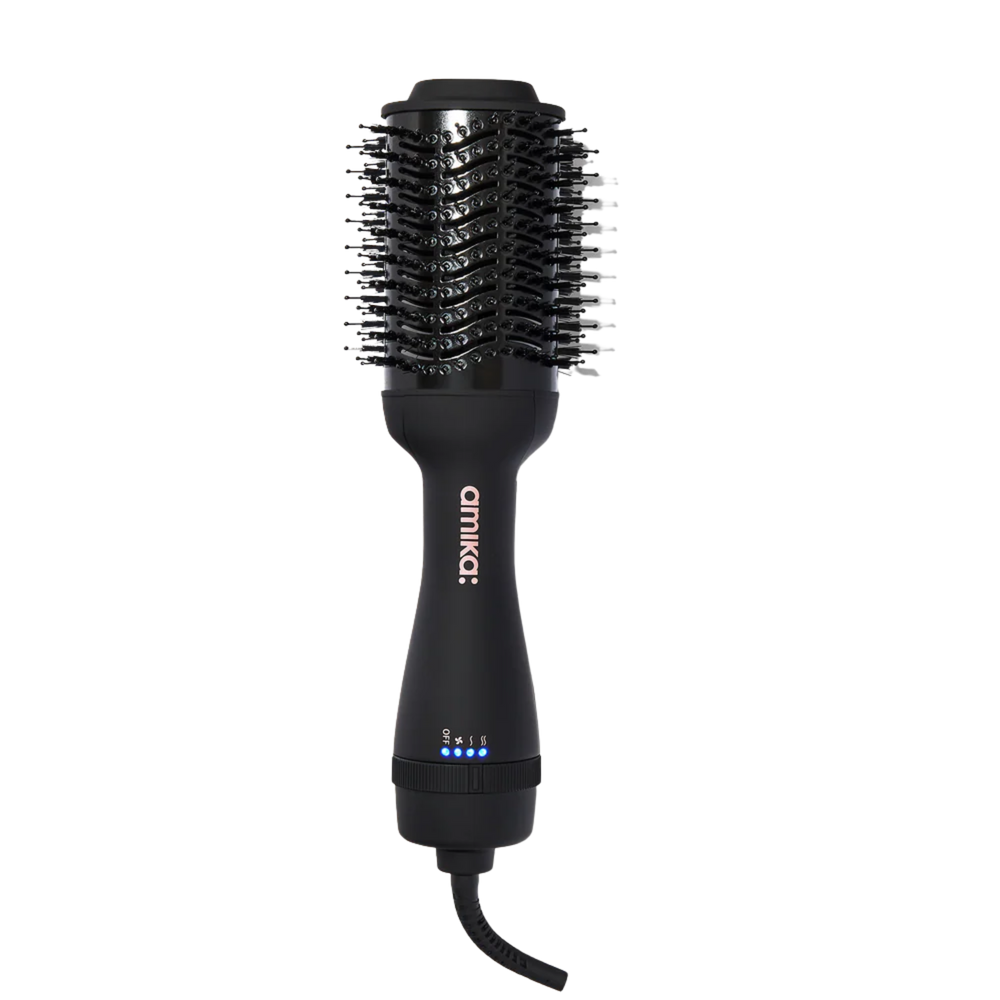 Brosse soufflante Amika HĒMĀIREM Blow Dryer Brush 2.0 posée sur fond blanc