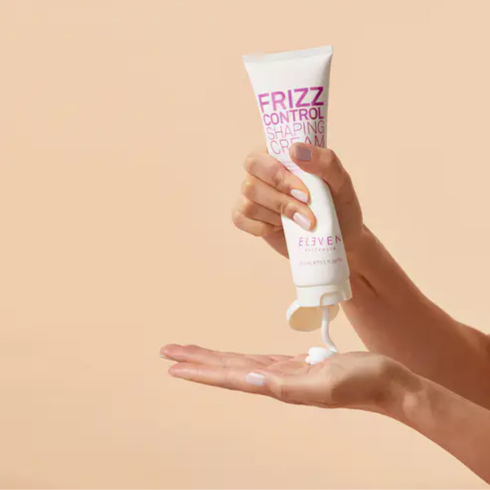 Pot de la crème Frizz Control Shaping Cream d’ELEVEN Australia sur fond neutre, texture crème lissante anti‑frisottis