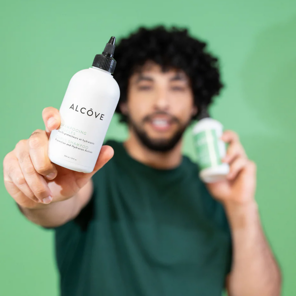 “Bouteille de Shampoing Boucles Alcôve sur fond clair – cheveux bouclés”