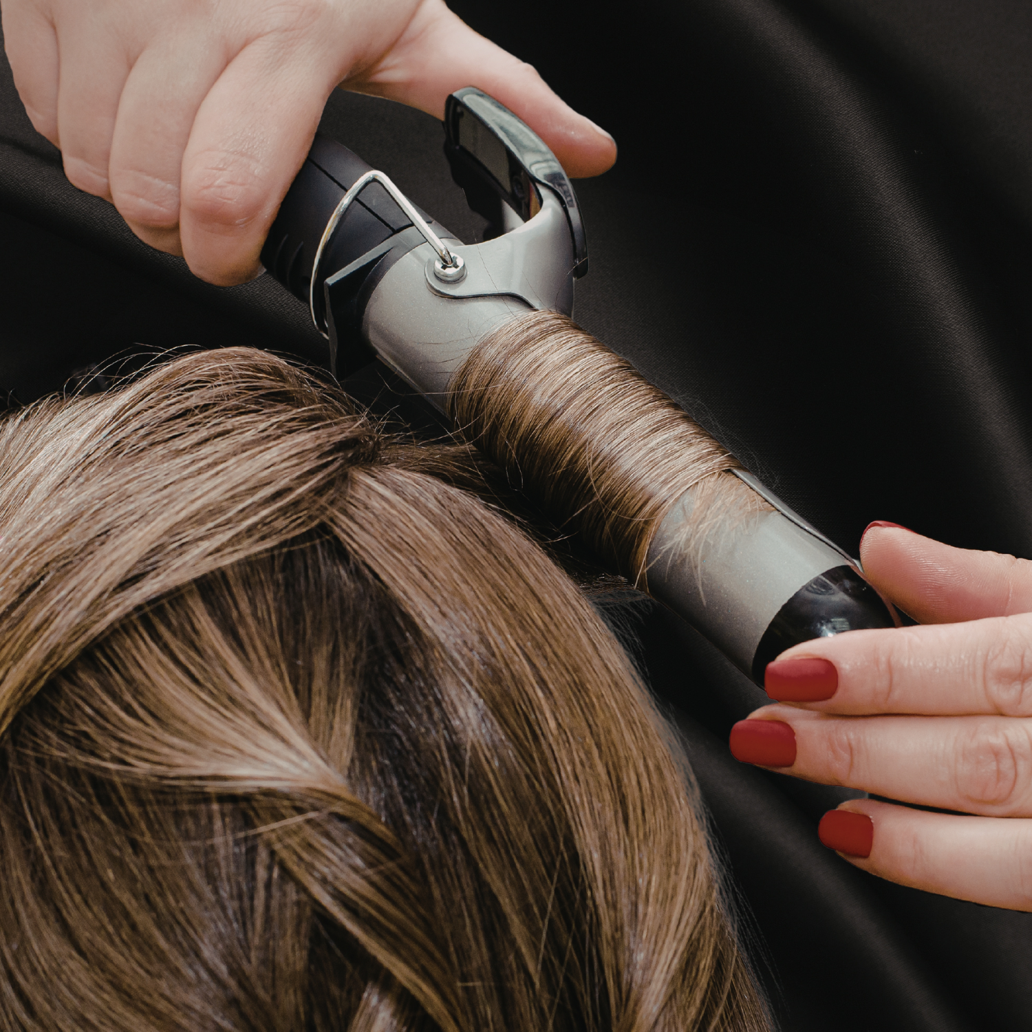 Cheveux châtain en train d’être bouclés coiffage professionnel boucles volumineuses et brillantes grâce aux produits coiffant professionnel du Cachet Urbain