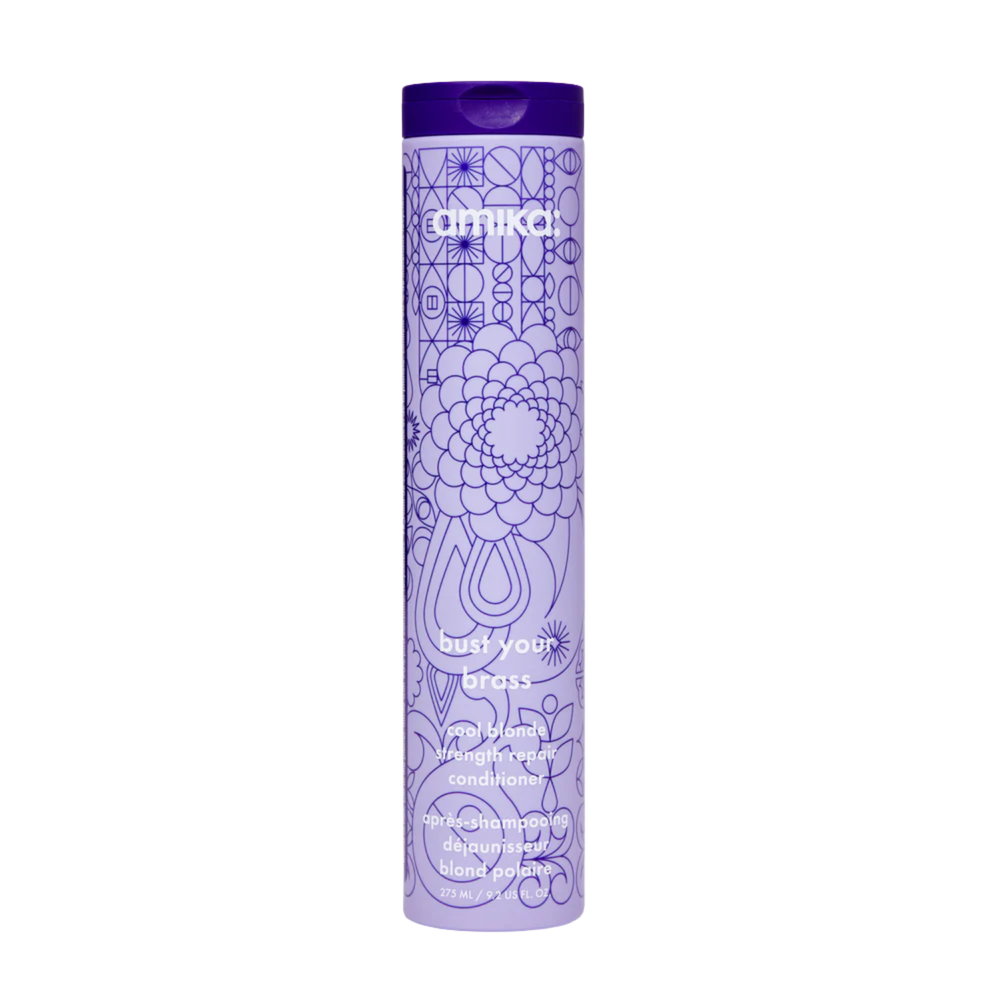 Flacon du conditionneur Amika Bust Your Brass 275 ml posé sur fond blanc

