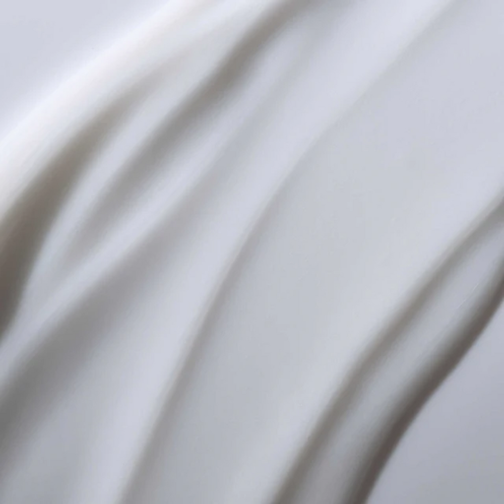 Flacon beige clair de l’après‑shampoing No Frizz Conditioner, design épuré, posé sur fond neutre évoquant douceur, contrôle des frisottis et soin capillaire professionnel.


