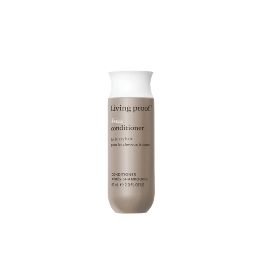 Flacon beige clair de l’après‑shampoing No Frizz Conditioner, design épuré, posé sur fond neutre évoquant douceur, contrôle des frisottis et soin capillaire professionnel.


