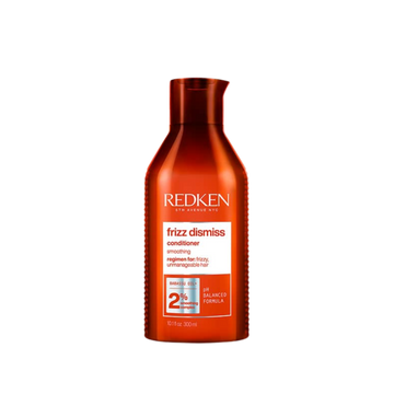 Flacon de l’après‑shampooing Redken Frizz Dismiss, formule sans sulfates, enrichie en huile de babassu, idéal anti‑frisottis.
