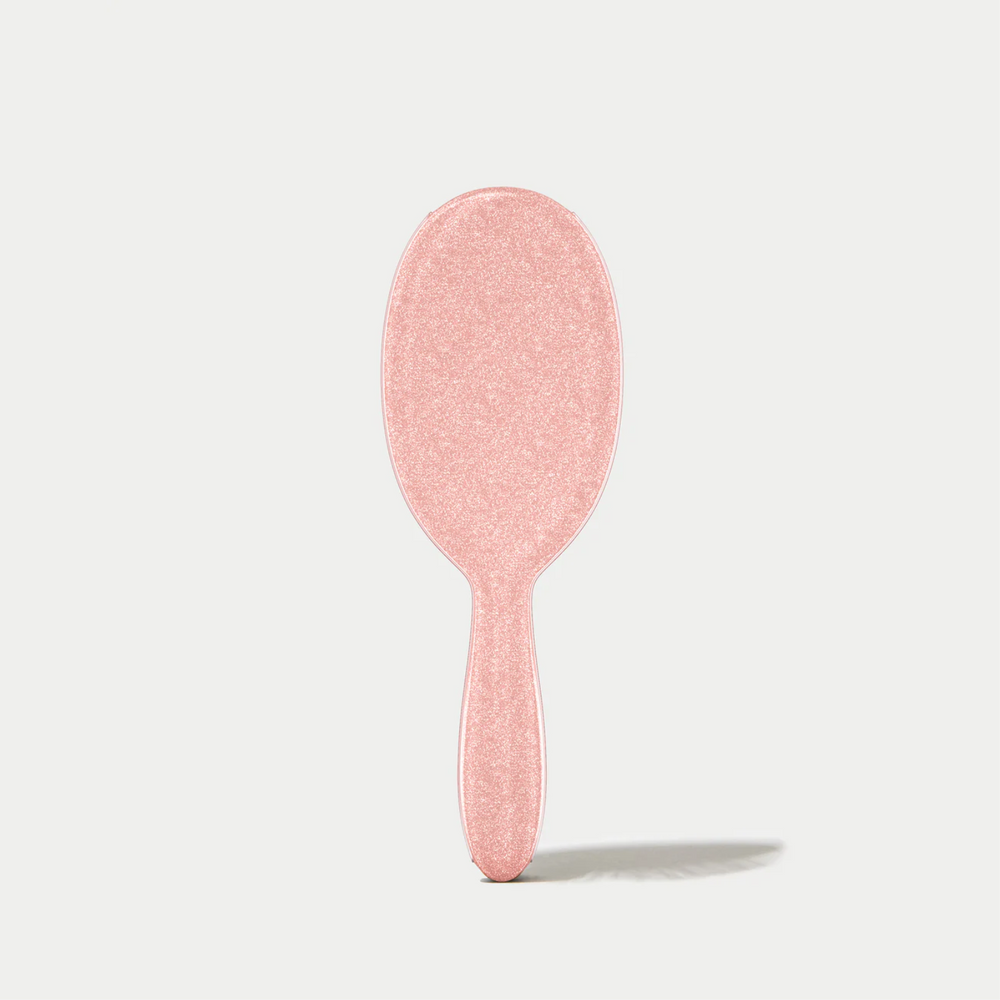 Brosse démêlante Framar Ginger avec poils flexibles et manche pailleté doré.