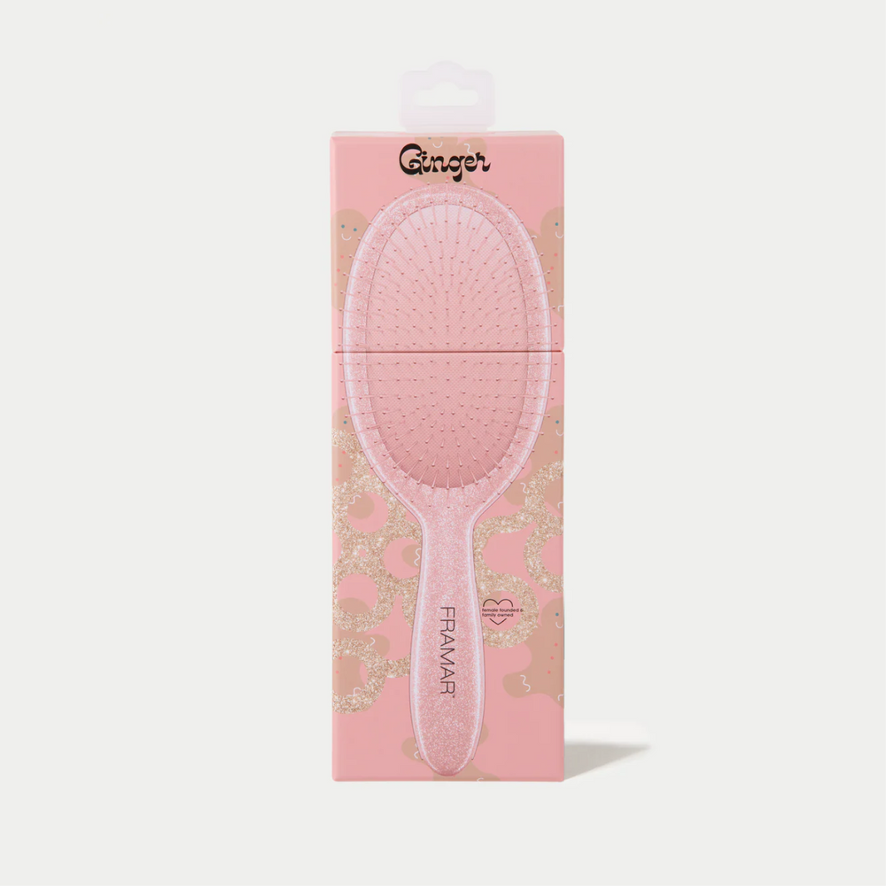 Brosse démêlante Framar Ginger avec poils flexibles et manche pailleté doré.