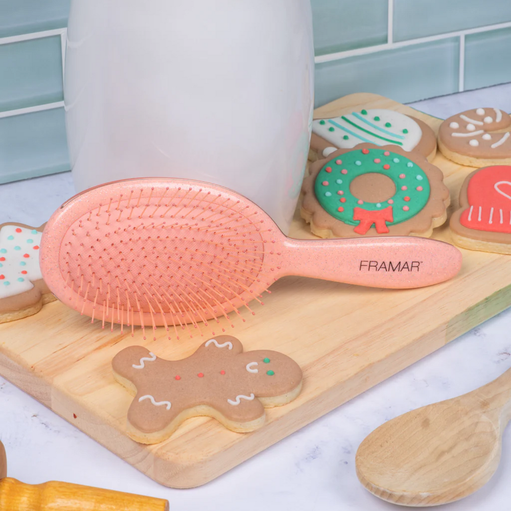 Brosse démêlante Framar Ginger avec poils flexibles et manche pailleté doré.