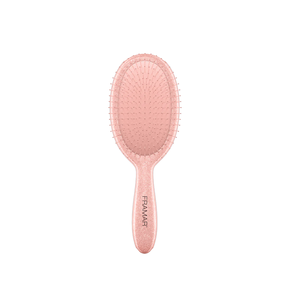 Brosse démêlante Framar Ginger avec poils flexibles et manche pailleté doré.