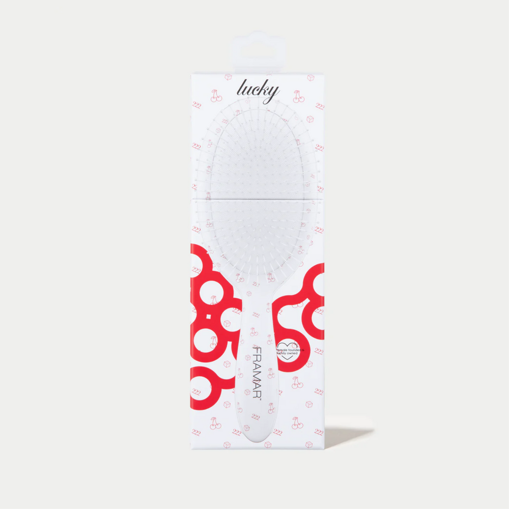 Brosse démêlante Framar Lucky blanche avec poils flexibles.
