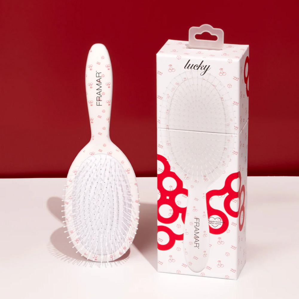 Brosse démêlante Framar Lucky blanche avec poils flexibles.