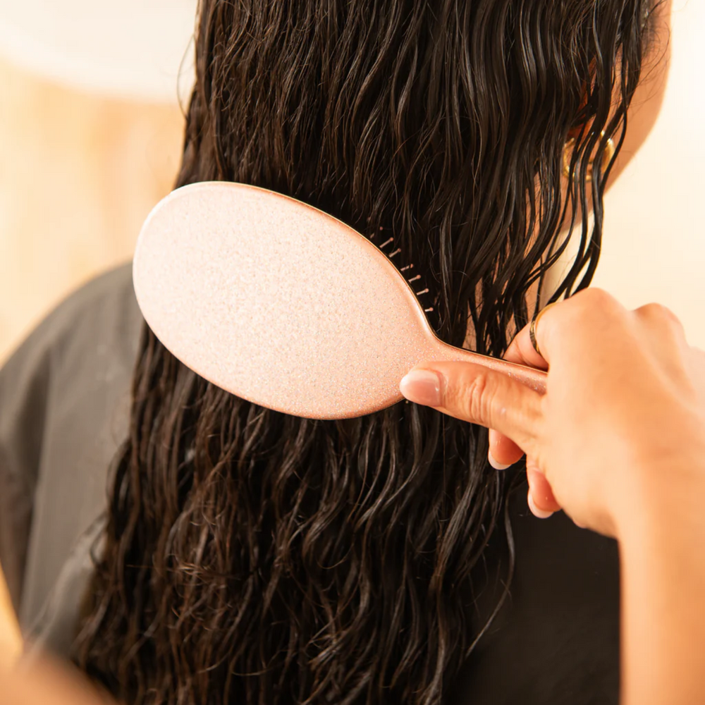 Brosse démêlante Framar Rose Gold Glitter avec poils flexibles et manche pailleté rose doré.