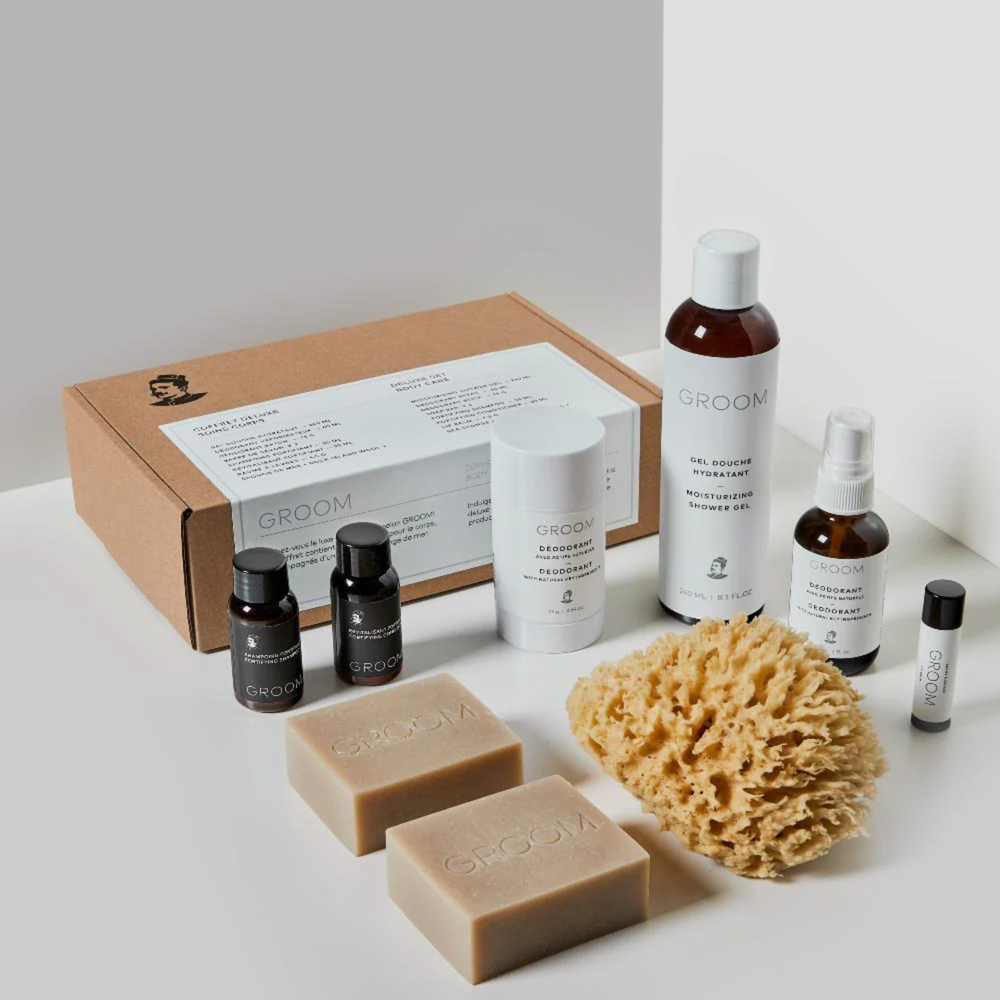 Coffret Deluxe – Soins corps Groom : ensemble de soins naturels pour hommes, comprenant gel douche, déodorants, savons, shampoing, revitalisant, baume à lèvres et éponge de mer.

