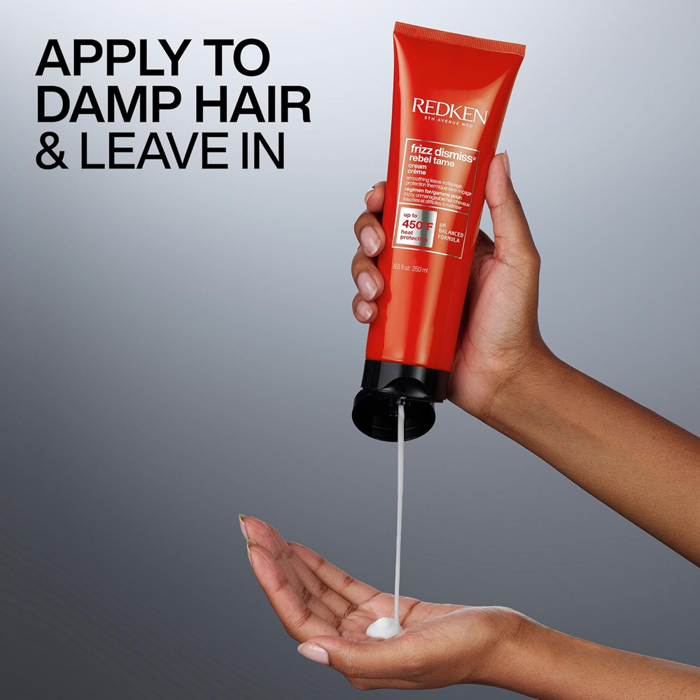 Tube de la crème sans rinçage Rebel Tame de Redken posé sur fond clair, formule anti‑frisottis enrichie en huile de babassu, protection thermique jusqu’à 230 °C.