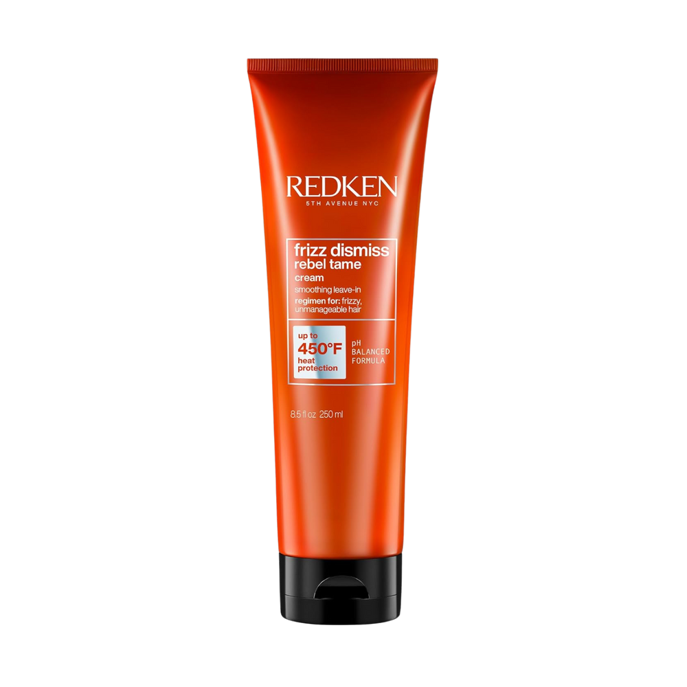 Tube de la crème sans rinçage Rebel Tame de Redken posé sur fond clair, formule anti‑frisottis enrichie en huile de babassu, protection thermique jusqu’à 230 °C.