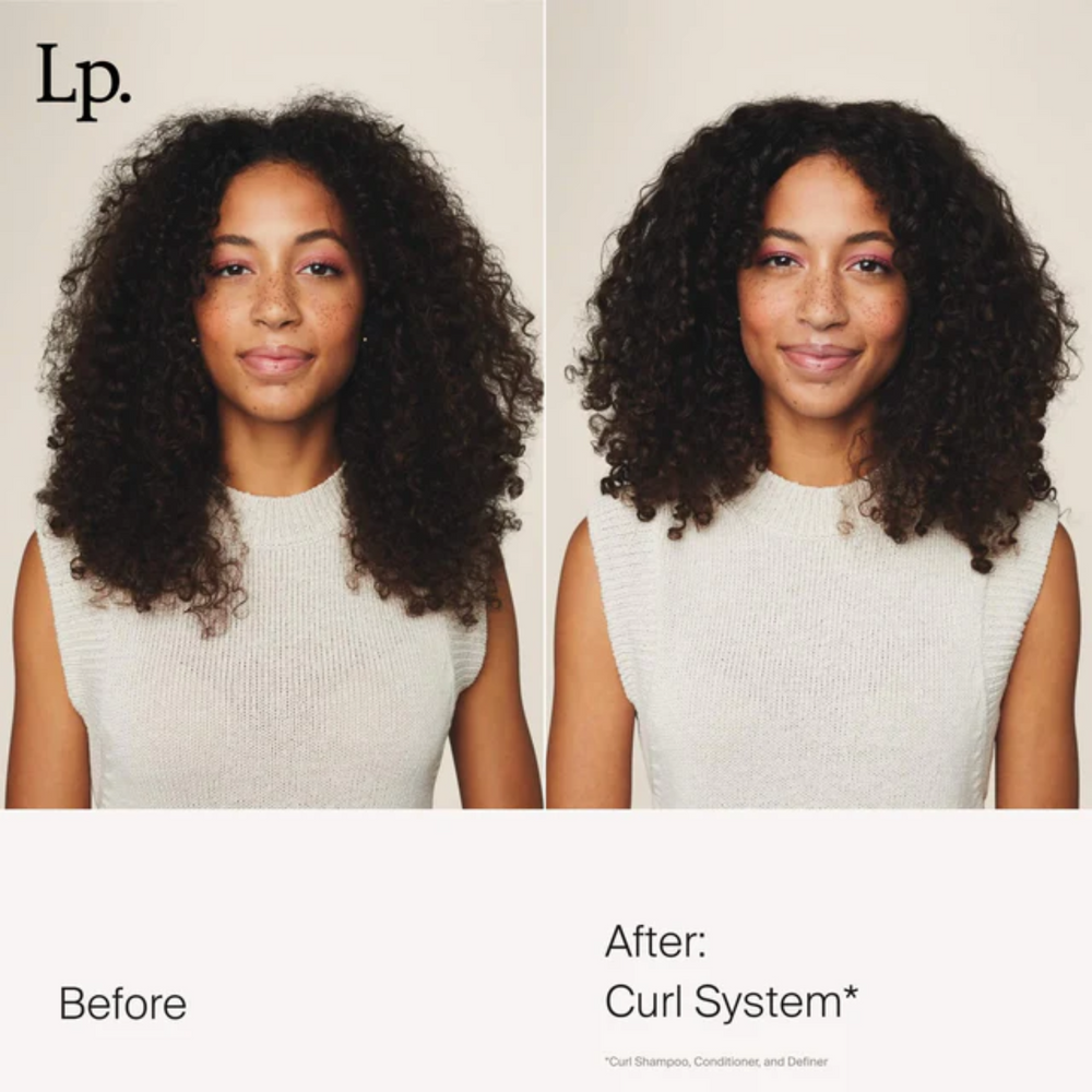 Tube corail du Curl Definer Living Proof avec pompe blanche, posé sur fond clair et montrant sa texture lisse et son design épuré.

