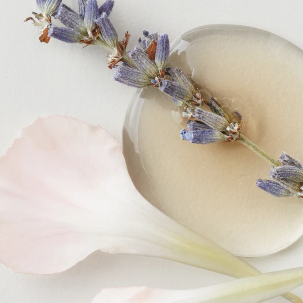 Spray AG Care Deflect Fast‑Dry Heat Protection, flacon transparent, cheveux lisses et brillants en arrière-plan