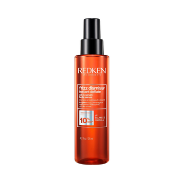 Flacon du sérum huile Redken Frizz Dismiss Instant Deflate, soin anti‑frisottis leave‑in enrichi en huile de babassu, pour cheveux lisses et brillants.