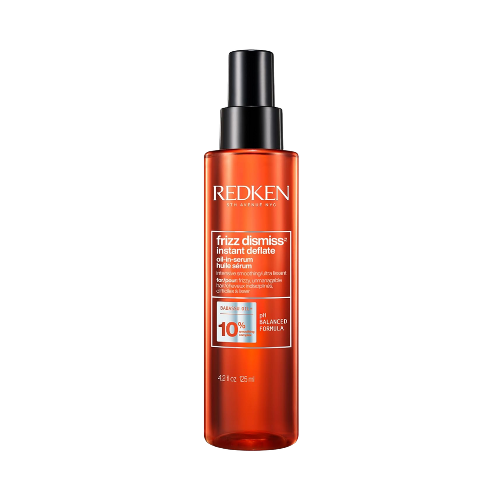 Flacon du sérum huile Redken Frizz Dismiss Instant Deflate, soin anti‑frisottis leave‑in enrichi en huile de babassu, pour cheveux lisses et brillants.