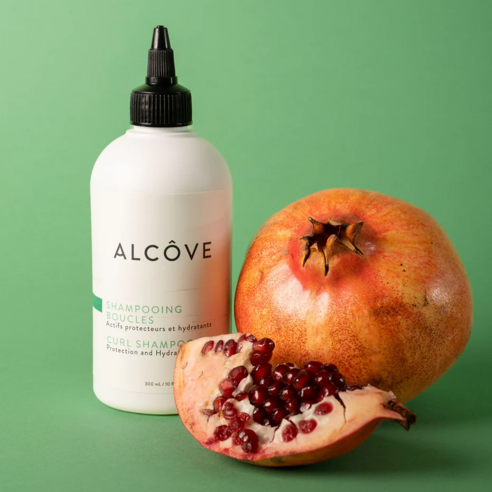 “Bouteille de Shampoing Boucles Alcôve sur fond clair – cheveux bouclés”