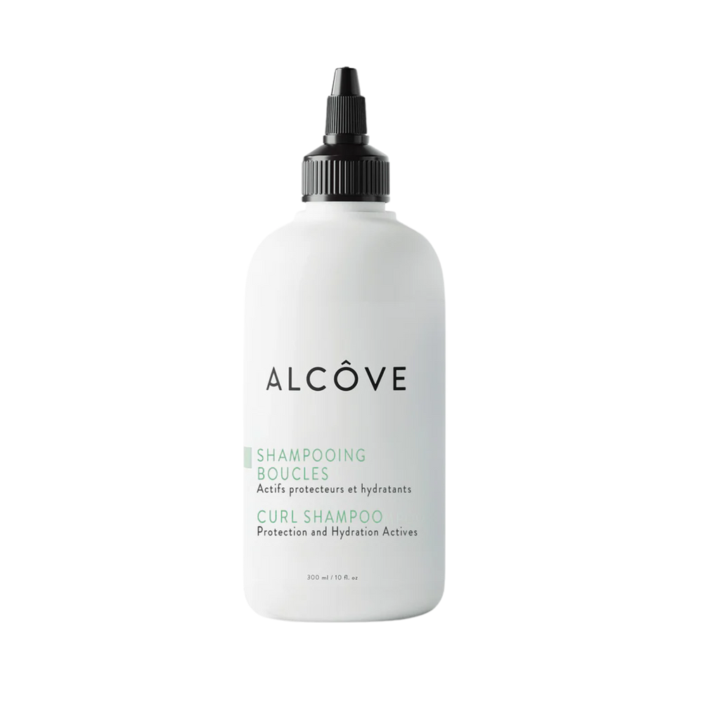 “Bouteille de Shampoing Boucles Alcôve sur fond clair – cheveux bouclés”