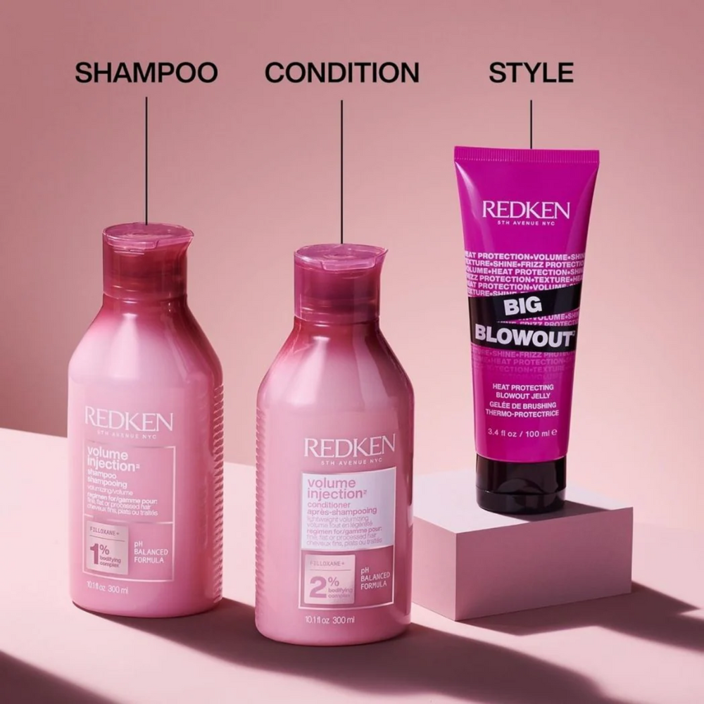Flacon 1000 ml du shampooing Volume Injection Redken sur fond clair.