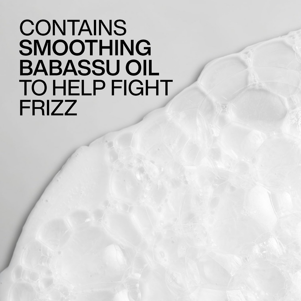 Flacon du shampooing Redken Frizz Dismiss sur fond blanc, formule anti‑frisottis sans sulfates, huile de babassu mise en avant.