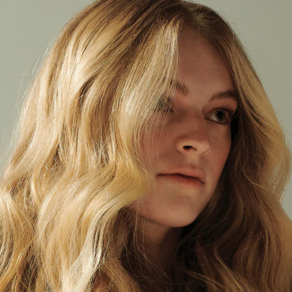 Flacon de AG CARE Simply Dry Shampoo sur fond blanc, cheveux volumineux en arrière-plan