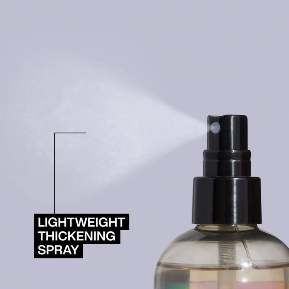 Flacon spray 250 ml du Volume Maximizer Redken posé sur fond neutre.