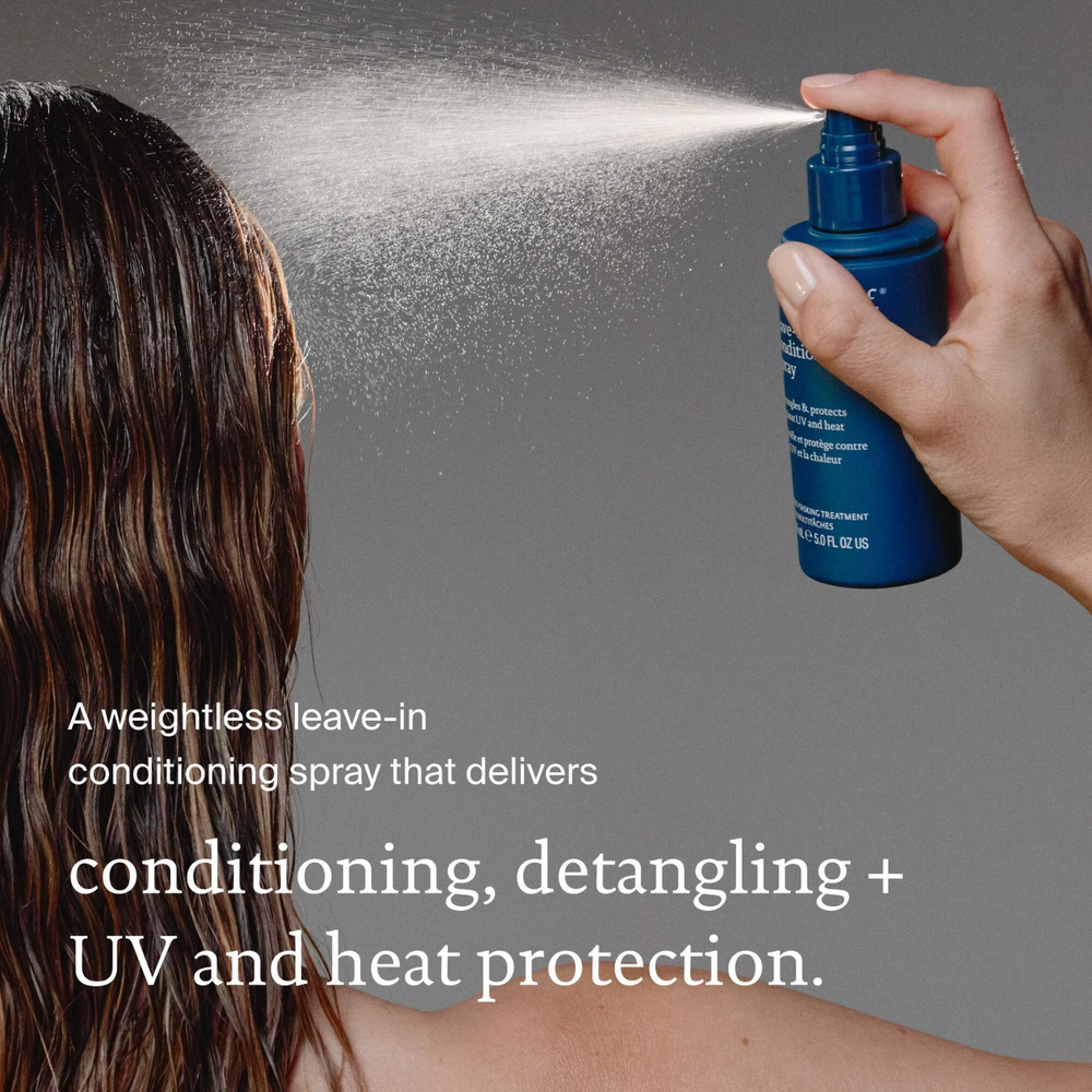 Flacon de spray sans rinçage Living Proof posé sur une surface claire, avec un fond neutre et des cheveux démêlés en arrière-plan


