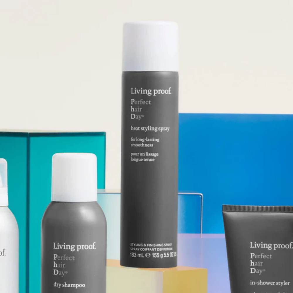 Flacon gris perle du spray Perfect Hair Day Heat Styling Spray de Living Proof, posé verticalement sur fond neutre, suggérant protection thermique et finition lisse.

