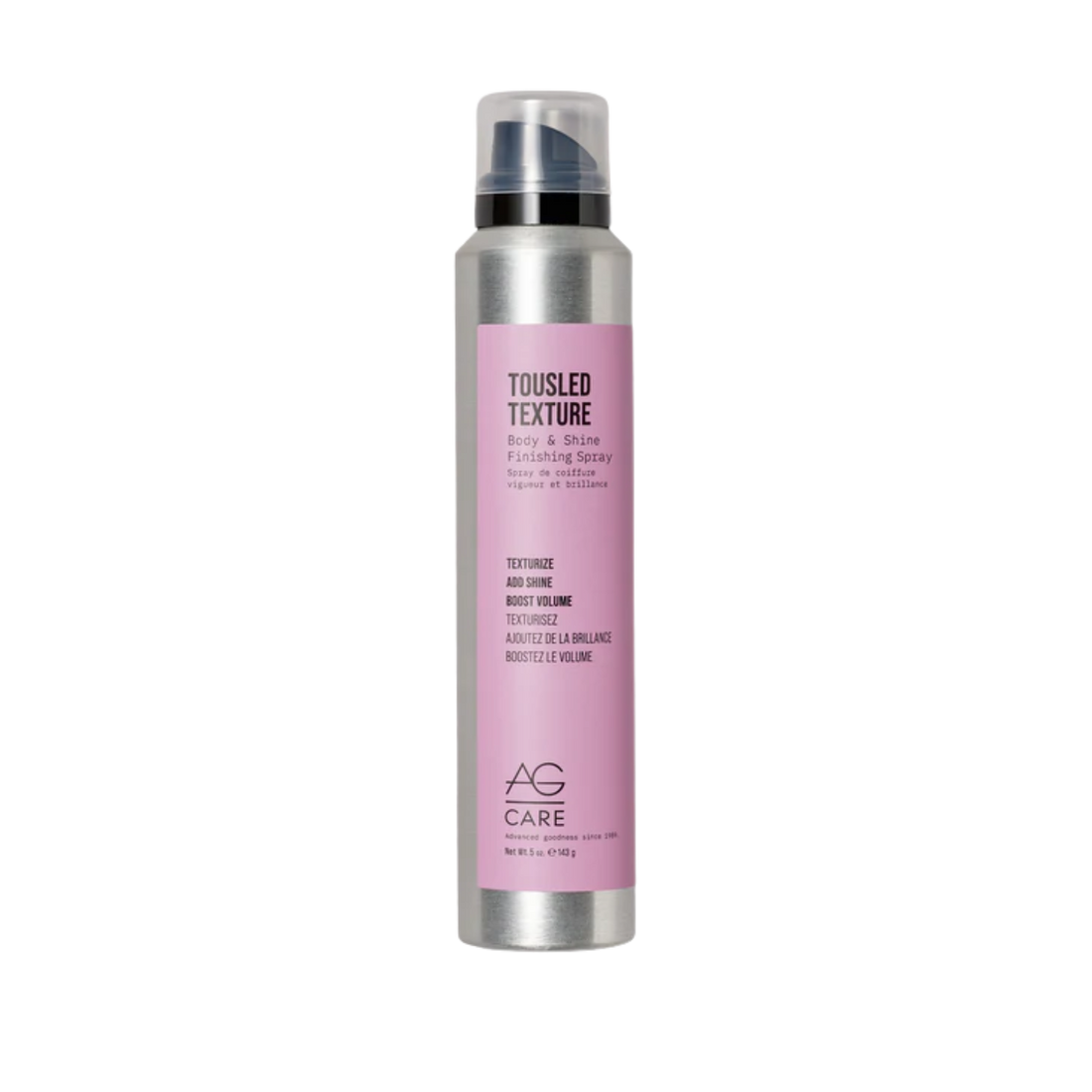 Spray AG Care Tousled Texture Body & Shine posé sur fond neutre, cheveux légèrement ondulés en arrière-plan